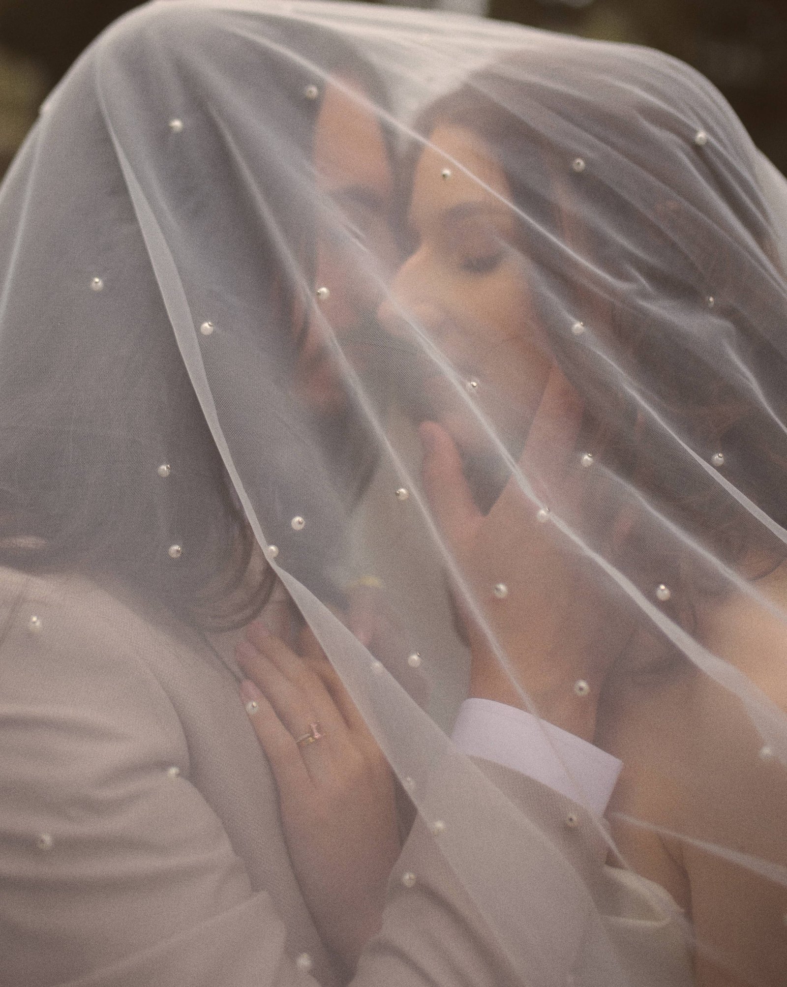 Wedding couple under a pearl veil